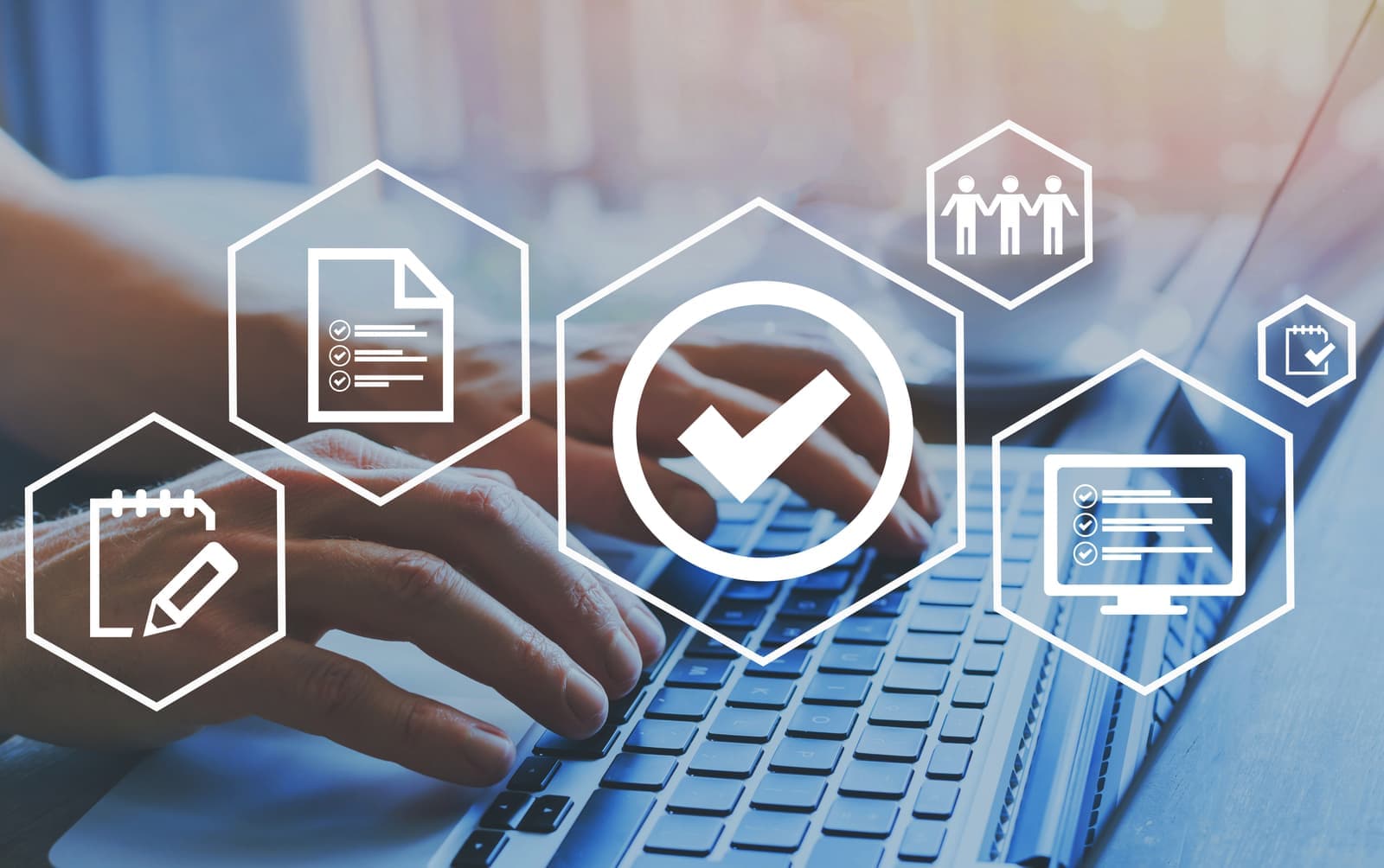 Hands typing on a laptop with document checklist and approval tick icons