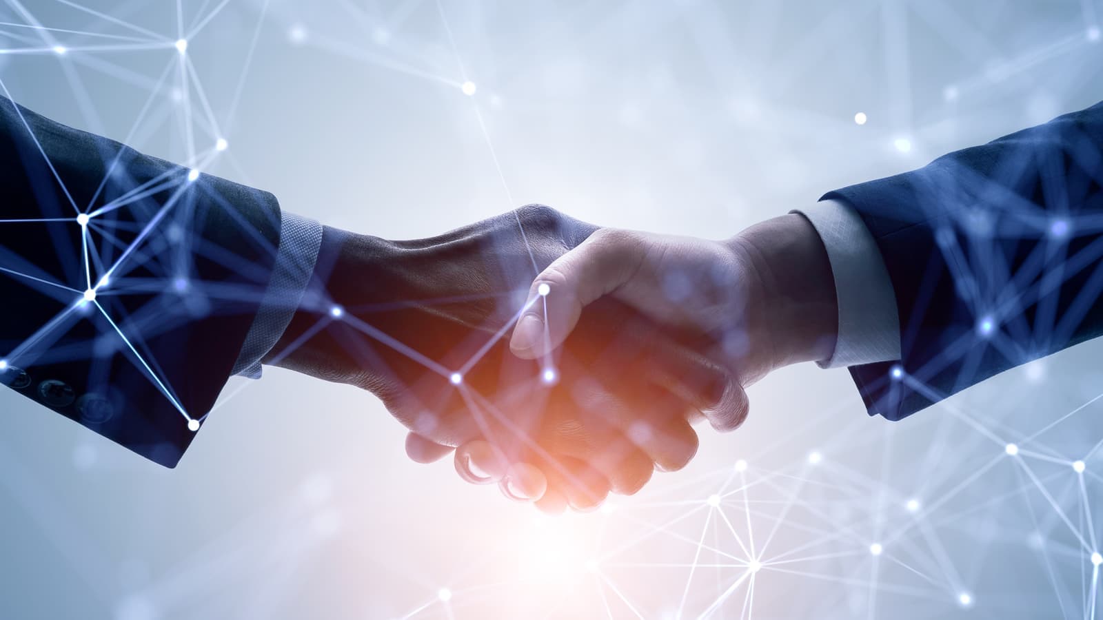 Two business people shaking hands over a connected network